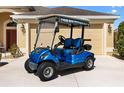Close up view of a blue golf cart with black seats parked on a concrete driveway at 3373 Melbourne Ln, The Villages, FL 32163