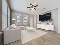 Stylishly staged living room featuring a modern sofa, large TV, and lots of natural light at 345 Alcove Dr, Groveland, FL 34736
