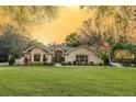 Inviting single-story home featuring a manicured lawn, mature trees, and traditional architectural details at 36845 Taylor Mill Rd, Fruitland Park, FL 34731