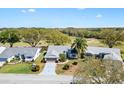 Aerial view of a well-maintained home near a golf course with lush landscaping and a patterned driveway at 3909 River Crest Cir, Leesburg, FL 34748