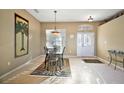 Bright dining area featuring a chandelier, animal print rug, a window, and front door with decor at 4818 Sawgrass Lake Cir, Leesburg, FL 34748