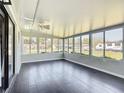 Bright sun room with expansive windows, ceiling fan, and durable plank flooring at 4857 Se 137Th Pl, Summerfield, FL 34491