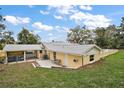 Expansive backyard with a patio, chain link fence and a covered parking area at 502 Lake Gracie Dr, Eustis, FL 32726