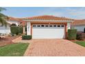 Attached two-car garage with brick paver driveway at 5056 Harbour Dr, Oxford, FL 34484