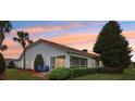 A home's rear exterior shows a screen porch, landscaping, and chairs to sit and enjoy the backyard at 5056 Harbour Dr, Oxford, FL 34484