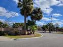 Riverside Landings community entrance featuring lush palm trees and attractive signage under a partly cloudy sky at 5214 Via Hacienda Cir # A308, Orlando, FL 32839