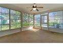 Enclosed lanai with wall-to-wall windows that provide serene views of the surrounding landscape at 5402 Rosewall Cir, Leesburg, FL 34748