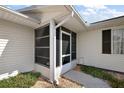 Exterior view of a screened-in porch with access to the home's entrance at 6022 Wilander St, Leesburg, FL 34748