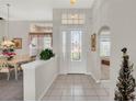 Bright foyer with tile flooring, decorative glass front door, and adjacent dining area at 6122 Sailboat Ave, Tavares, FL 32778