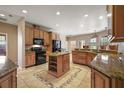 Well-appointed kitchen featuring custom wood cabinetry, granite countertops, and a central island at 6813 S Fork Ranch Dr, Clermont, FL 34714