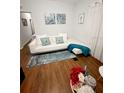 Bright living room featuring hardwood floors, a white couch and a blue rug at 728 Mckenzie St, Leesburg, FL 34748