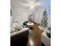 Cozy living room with modern furniture, hardwood floors, Christmas tree and white walls with art decorations at 728 Mckenzie St, Leesburg, FL 34748