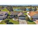 Aerial of home featuring lush landscaping, paver driveway and nearby serene lake at 776 Alcott Ave, The Villages, FL 32162