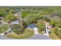An aerial view of the property showcasing its location within a lush, wooded neighborhood near a lake at 804 Deep Wood Ct, Fruitland Park, FL 34731