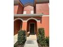 Inviting front door with arched entryway, bench and well-manicured shrubs at this two story home at 8973 Cat Palm Rd, Kissimmee, FL 34747