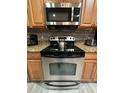 Modern stainless steel oven and microwave appliances with granite countertops and light wood cabinets at 8973 Cat Palm Rd, Kissimmee, FL 34747