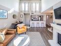 Open-concept living space with high ceilings, modern bar stools, and fireplace at 1051 S Highland St # 7E, Mount Dora, FL 32757