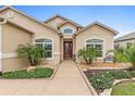 Beautiful home featuring manicured landscaping, a welcoming entryway, and a red front door at 10929 Se 167Th Pl, Summerfield, FL 34491