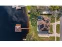 Aerial view showcasing a lakefront property with a private dock, pool, and solar panels at 11007 Lake Katherine Cir, Clermont, FL 34711