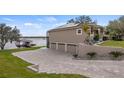 A house showcasing a spacious three-car garage and a paved driveway leading to the waterfront at 11007 Lake Katherine Cir, Clermont, FL 34711