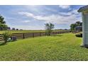 Lush backyard featuring a wooden fence, expansive green lawn, and serene landscape views at 1229 Augustine Dr, The Villages, FL 32159