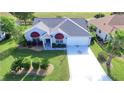 Charming single-story home with a well-manicured lawn and a long driveway leading to an attached garage at 1229 Augustine Dr, The Villages, FL 32159