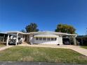 Charming home with dual carports, a well-manicured lawn, and inviting curb appeal at 146 Jacaranda Dr, Leesburg, FL 34748