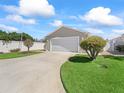 Well-maintained home with lush green lawn and driveway, features a garage and manicured landscaping at 1487 Gantt St, The Villages, FL 32162