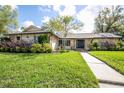 Charming single-story home with stone accents, manicured landscaping, and a welcoming front entrance with a walkway at 1494 Grace Lake Cir, Longwood, FL 32750