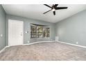 Well lit living room featuring neutral gray walls, large bay window, carpeted floor, and a ceiling fan at 1638 Leesburg Blvd, Fruitland Park, FL 34731
