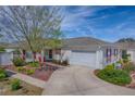 Charming home with a well-maintained lawn, driveway, and an attached two-car garage at 17714 Se 84Th Sheldon Ter, The Villages, FL 32162