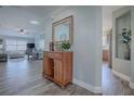 Spacious hallway with wood-look floors leading to the living room and kitchen at 17714 Se 84Th Sheldon Ter, The Villages, FL 32162