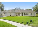 A single-story home boasts lush green lawn, side entry two-car garage, and a charming front porch at 1792 Presidio Dr, Clermont, FL 34711