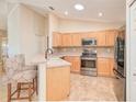 Well-lit kitchen featuring modern stainless steel appliances and barstool seating at peninsula at 181 Sutter Dr, Clermont, FL 34711