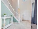 Inviting entryway features a white staircase and tiled floor, complemented by neutral wall tones at 2116 Lelani Cir, Davenport, FL 33897