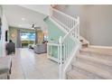 Bright entryway with tile floors, a staircase with white banister, and a view into the open-concept living area at 2116 Lelani Cir, Davenport, FL 33897