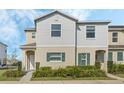 Inviting two-story townhouse with light gray siding, green shutters, and well-manicured shrubbery at 213 Primrose Dr, Davenport, FL 33837