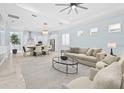 Bright and open-concept living room with modern furnishings and a seamless flow to the kitchen and dining area at 2174 Wallingford Loop, Mount Dora, FL 32757