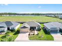 Aerial view of a residential property with a landscaped yard, neighboring homes, and an expansive green space nearby at 2188 Gordon Path, The Villages, FL 32163