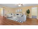 Cozy living room with hardwood floors, a ceiling fan, and comfortable white sofa at 2376 Bexley Dr, Tavares, FL 32778