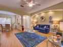 Bright living room features wood floors, a blue sofa, and stylish decor, offering a cozy and inviting space at 24104 Robinwood St, Leesburg, FL 34748