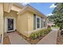 Charming home featuring light yellow stucco walls and a meticulously maintained landscape at 257 Winding Cove Ave, Apopka, FL 32703