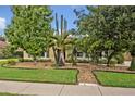 Well-manicured front yard with lush landscaping and a variety of trees and plants at 257 Winding Cove Ave, Apopka, FL 32703