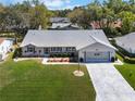 An aerial shot of a lovely single-story home, showcasing its landscaping and long driveway at 26800 Racquet Cir, Leesburg, FL 34748