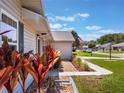 A lovely home showing the side of the home and lush landscaping against a sunny sky at 26800 Racquet Cir, Leesburg, FL 34748