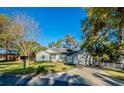 Inviting single-story home featuring a lush front lawn, mature trees, and a welcoming driveway at 351 Groveland Rd, Mount Dora, FL 32757