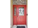 Inviting red front door with decorative wreath and stone accents, enhancing the curb appeal of the home at 3909 Cr 532A, Bushnell, FL 33513