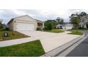 Long driveway leads to a two car garage with a manicured lawn in a residential neighborhood at 412 Lady Bella Pl, Deland, FL 32724