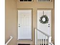 A closer view of the front doors to the townhouses with one adorned with a wreath and a white railing at 5359 Compass Pt, Oxford, FL 34484