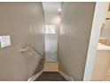 A view of the hallway from the top of the stairs with a small window and neutral wall colors at 5359 Compass Pt, Oxford, FL 34484